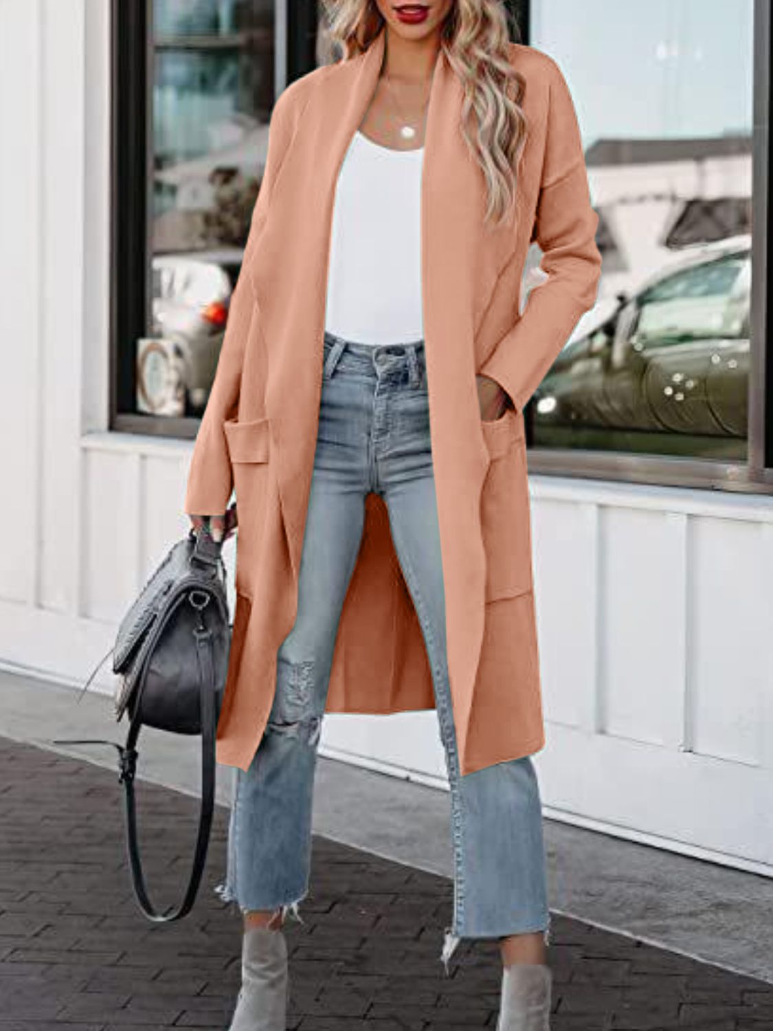 Coral open-front duster cardigan with pockets, worn open over a white top and jeans.