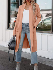 Coral open-front duster cardigan with pockets, worn open over a white top and jeans.