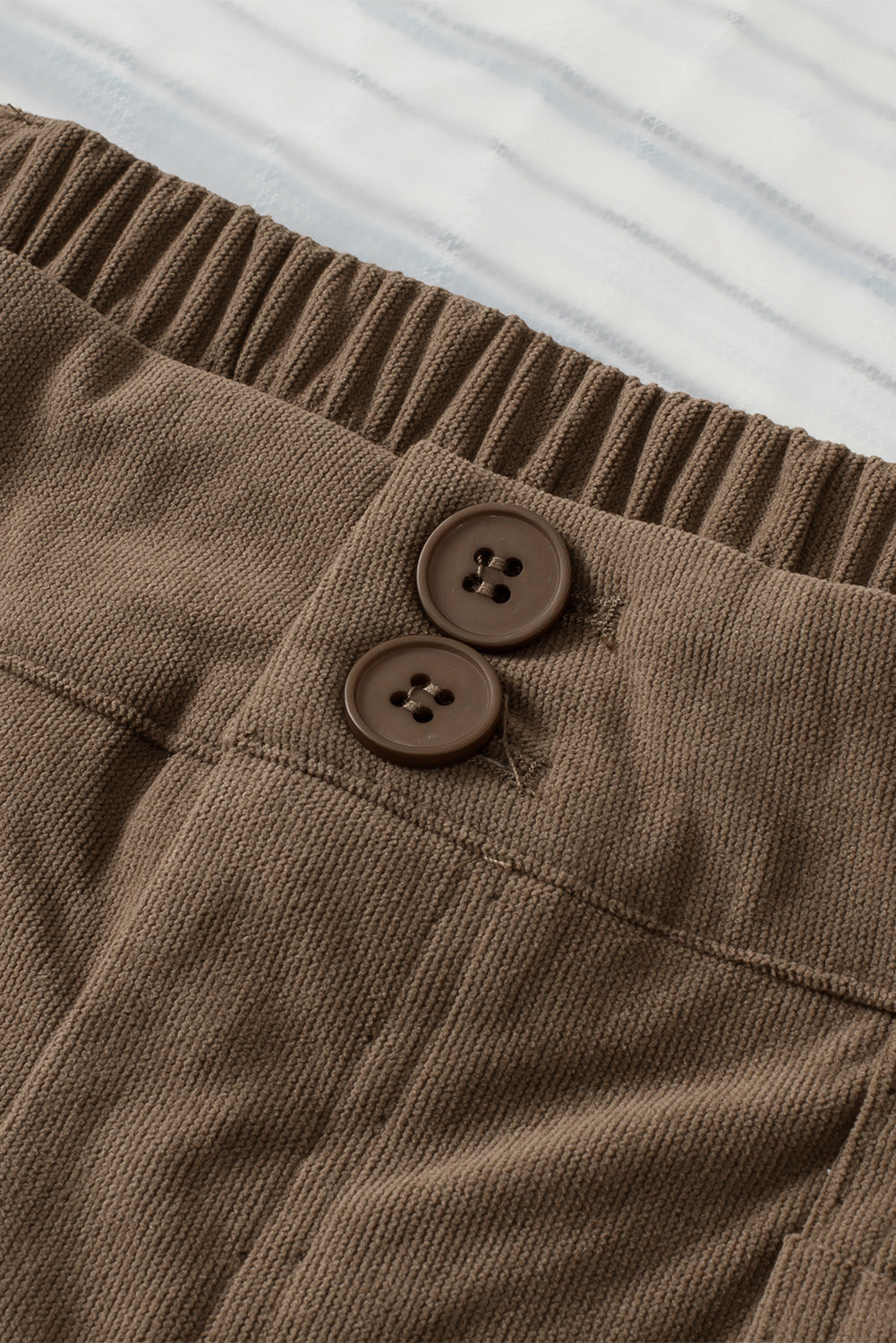 Caramel seamed front wide leg trousers with elastic waistband and two button details.