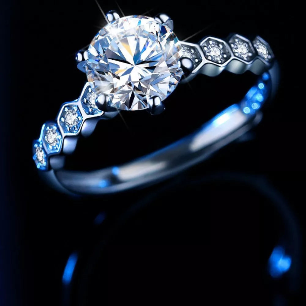 Radiant moissanite silver ring with hexagonal band and small accent diamonds.