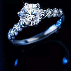 Radiant moissanite silver ring with hexagonal band and small accent diamonds.