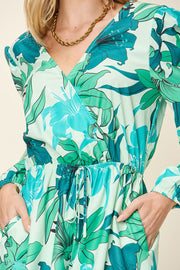 Green floral wrap romper with V-neck, cinched waist, and long sleeves.