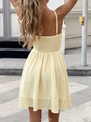 Yellow smocked bodice mini dress with a-line skirt and ruffled hem.