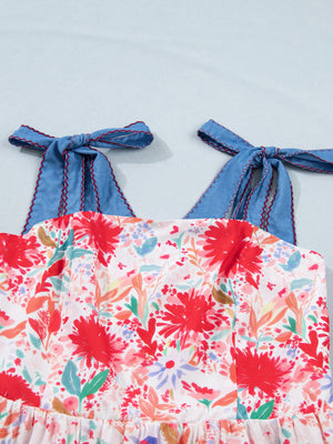 Floral print midi dress with blue tie-shoulder straps and red zigzag trim.