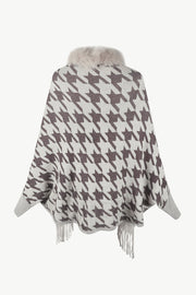 Houndstooth knit poncho with faux fur collar and fringe trim