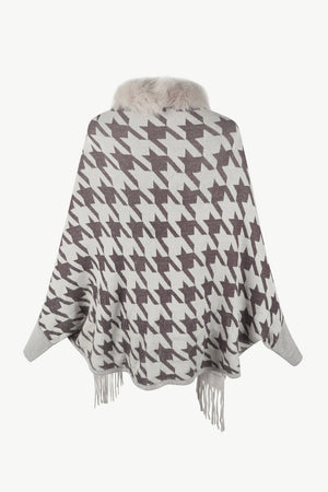 Houndstooth knit poncho with faux fur collar and fringe trim