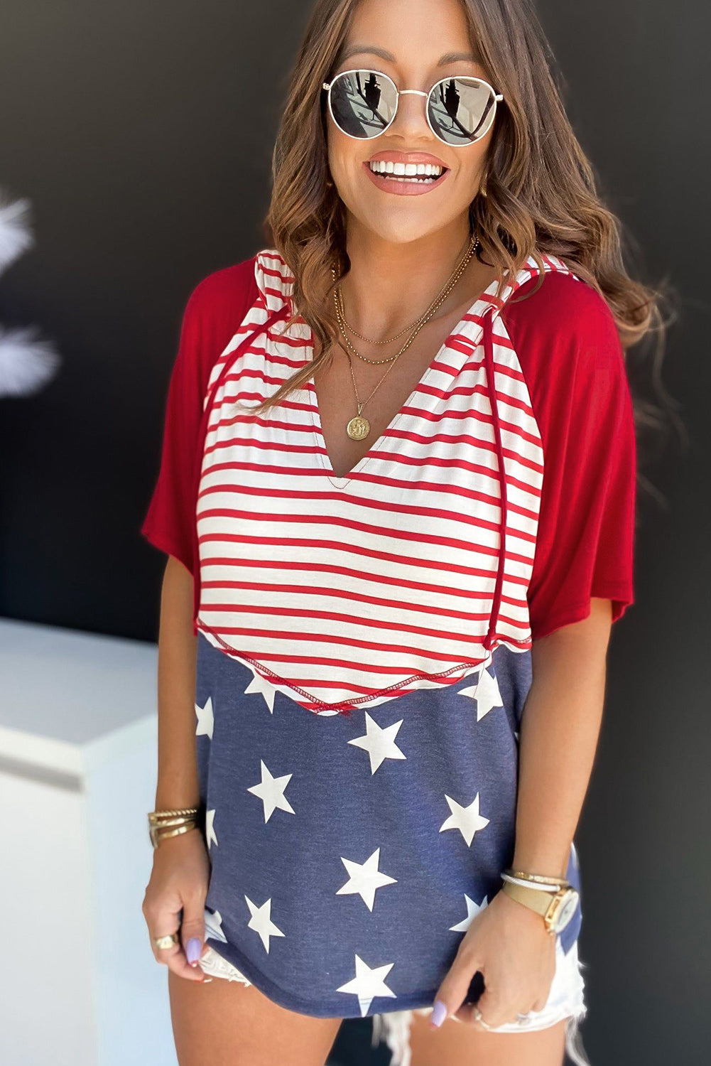 Patriotic hooded tee with red raglan sleeves, white and red striped chest, and blue star print bottom.