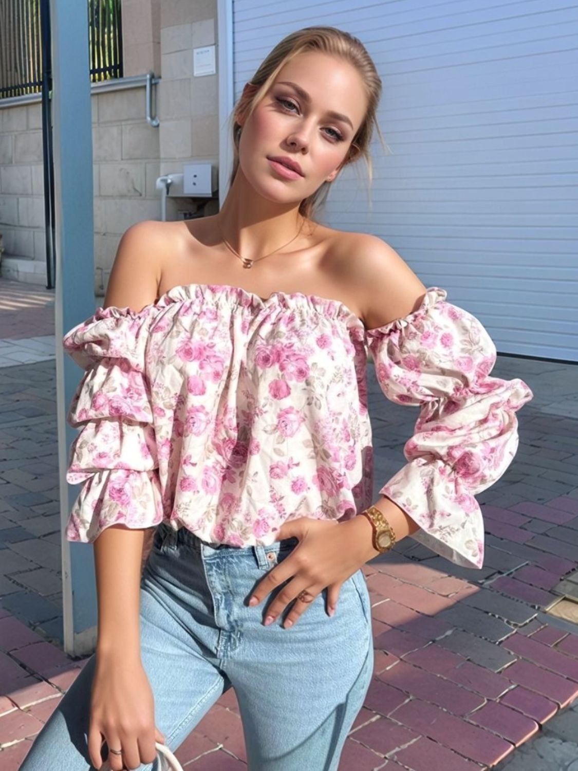 Off-the-shoulder blouse with floral print and ruffle sleeves in blush pink, styled with jeans.