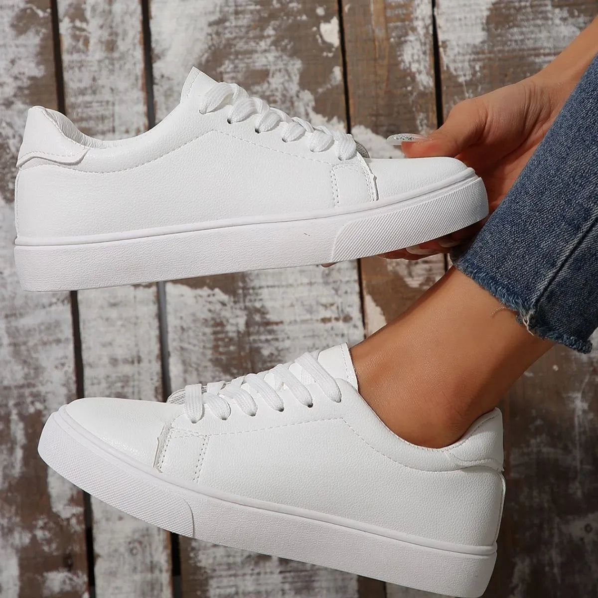 White leather-look platform sneakers with lace-up closure and round toe.