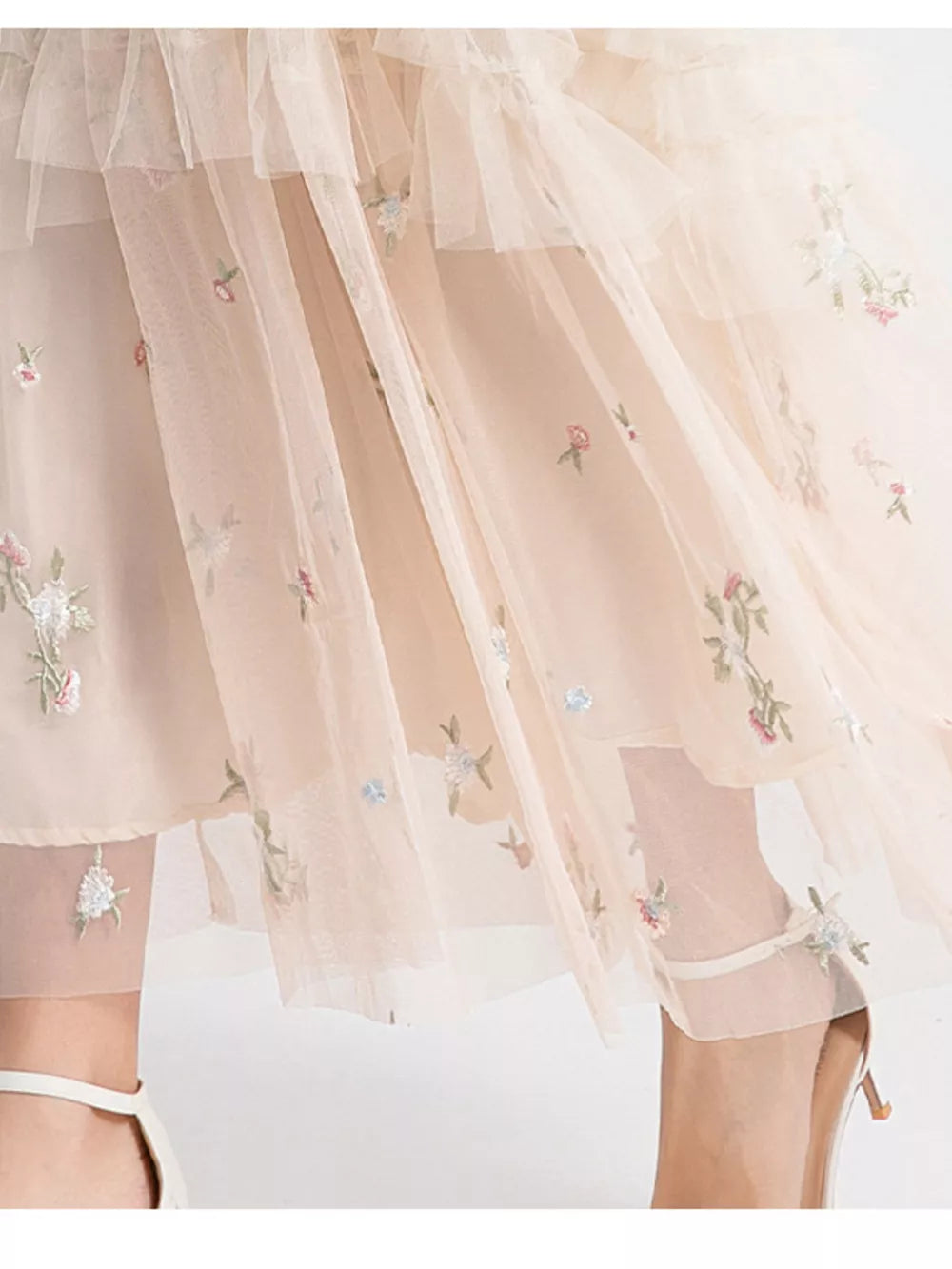 Embroidered floral tulle maxi gown with ruffled layers in a soft blush hue.
