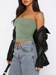 Sage gathered bustier bandeau top with ruched detail, styled with jeans and a leather jacket.