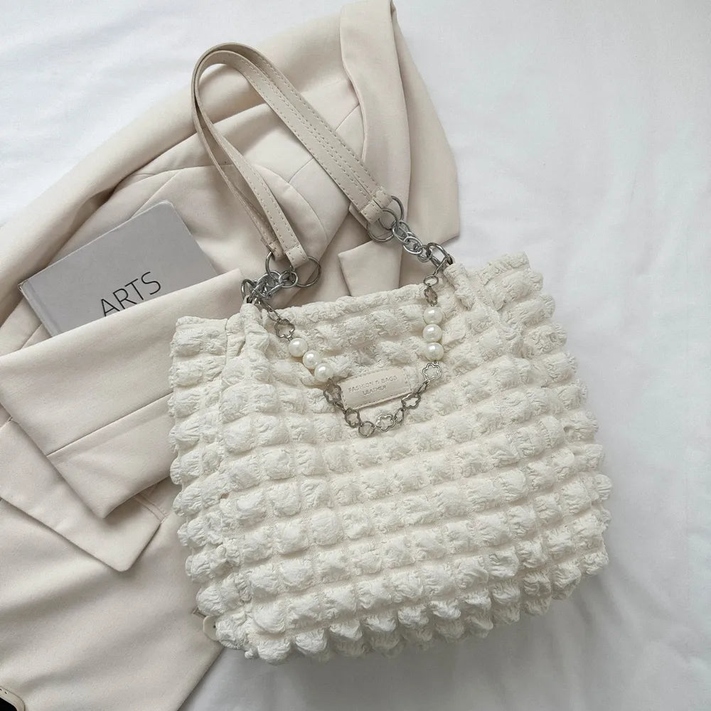 Textured grid pearl chain tote in ivory with a bubble pattern and chain detail.
