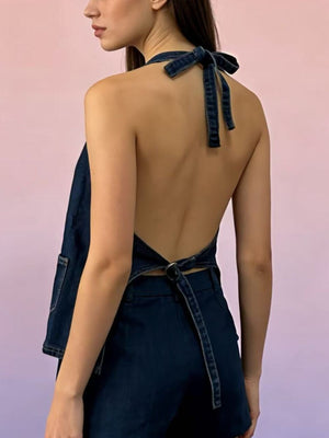 Button-down denim halter vest in dark blue with a tie back and pocket detail.