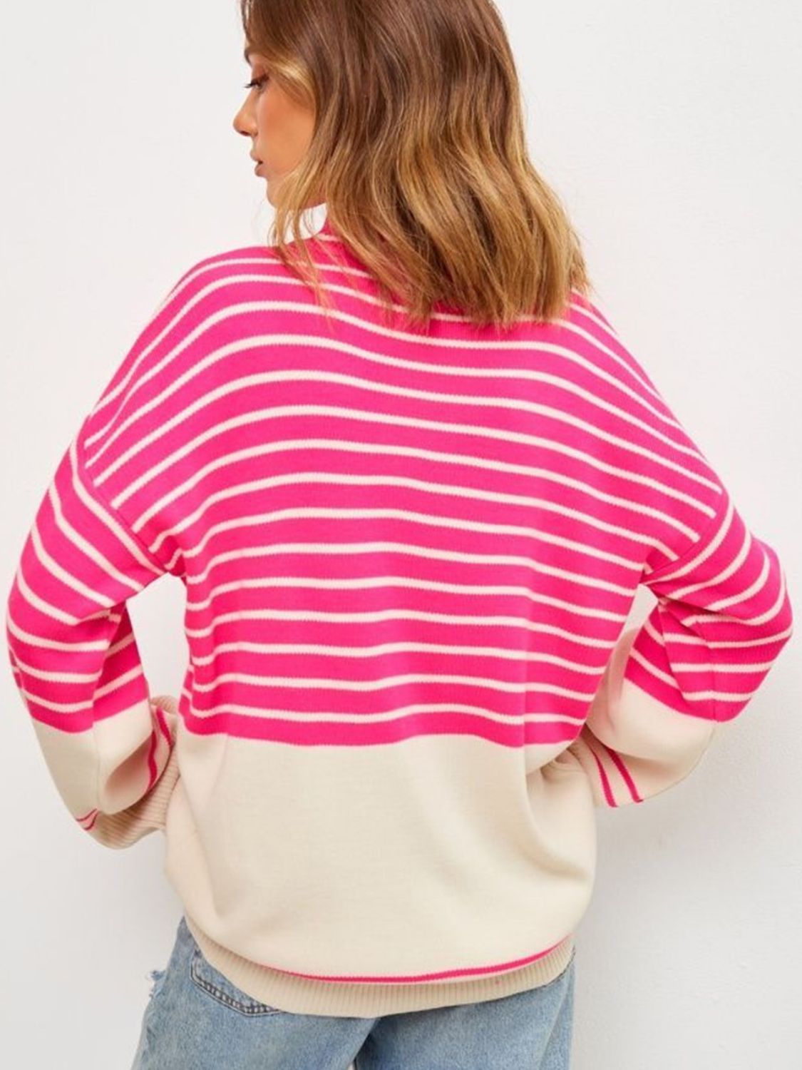 Colorblock stripe knit sweater with bell sleeves and a relaxed fit, shown in pink and cream.