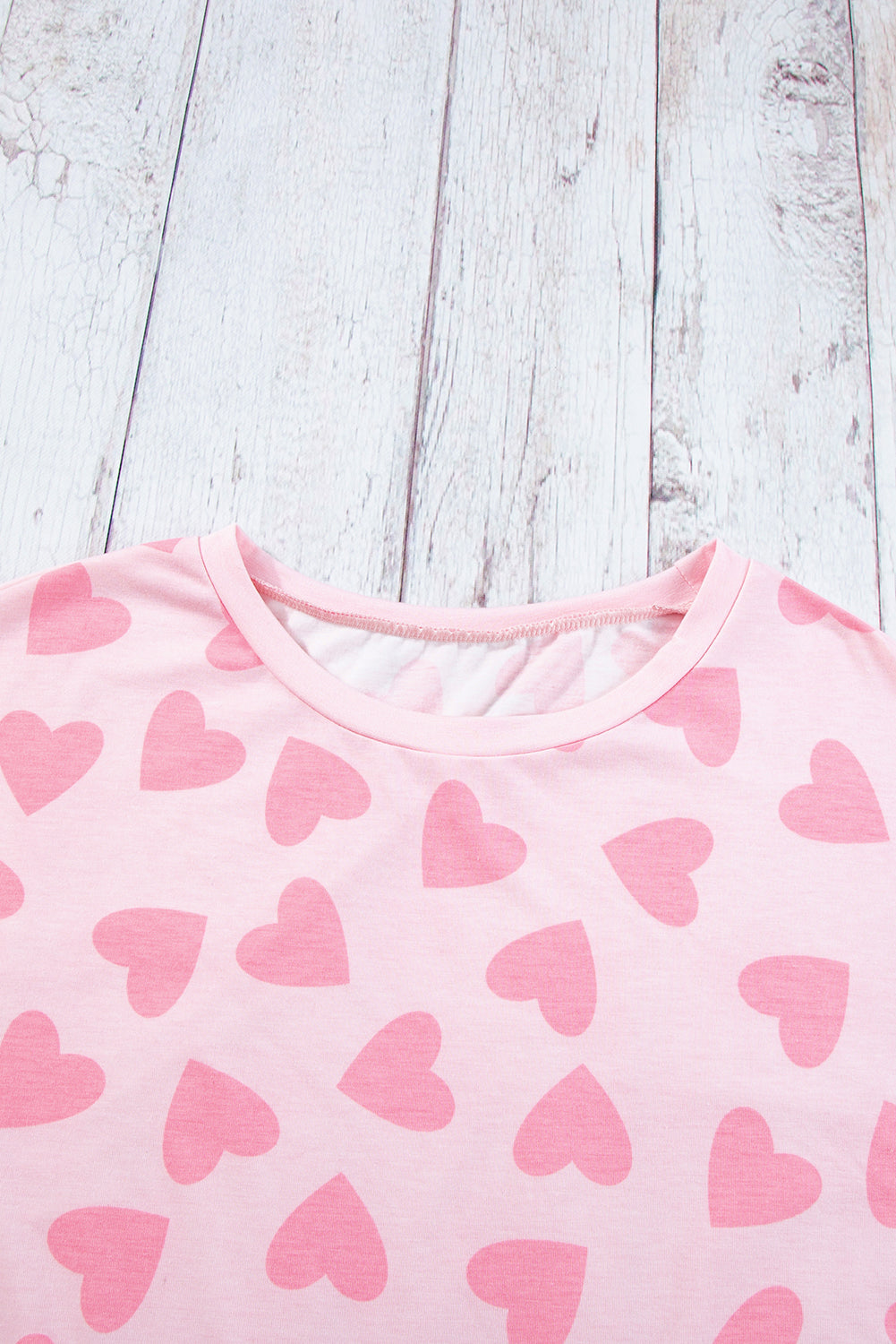 Blush pink pajama top with allover heart print and crew neck.