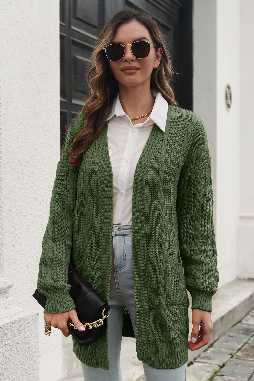 Army green cable knit longline cardigan with pockets, open front, and long sleeves.