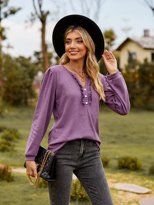 Dusty purple ruffled henley blouse with button detail and long sleeves.