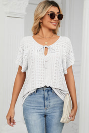 White eyelet tie-neck blouse with flutter sleeves and a keyhole cutout.