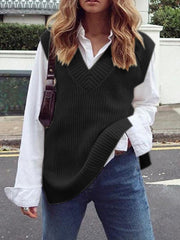 Black textured knit vest with v-neck and asymmetric hem, styled over a white shirt.