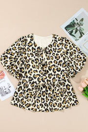 Leopard print peplum blouse with tie-neck and short puff sleeves.