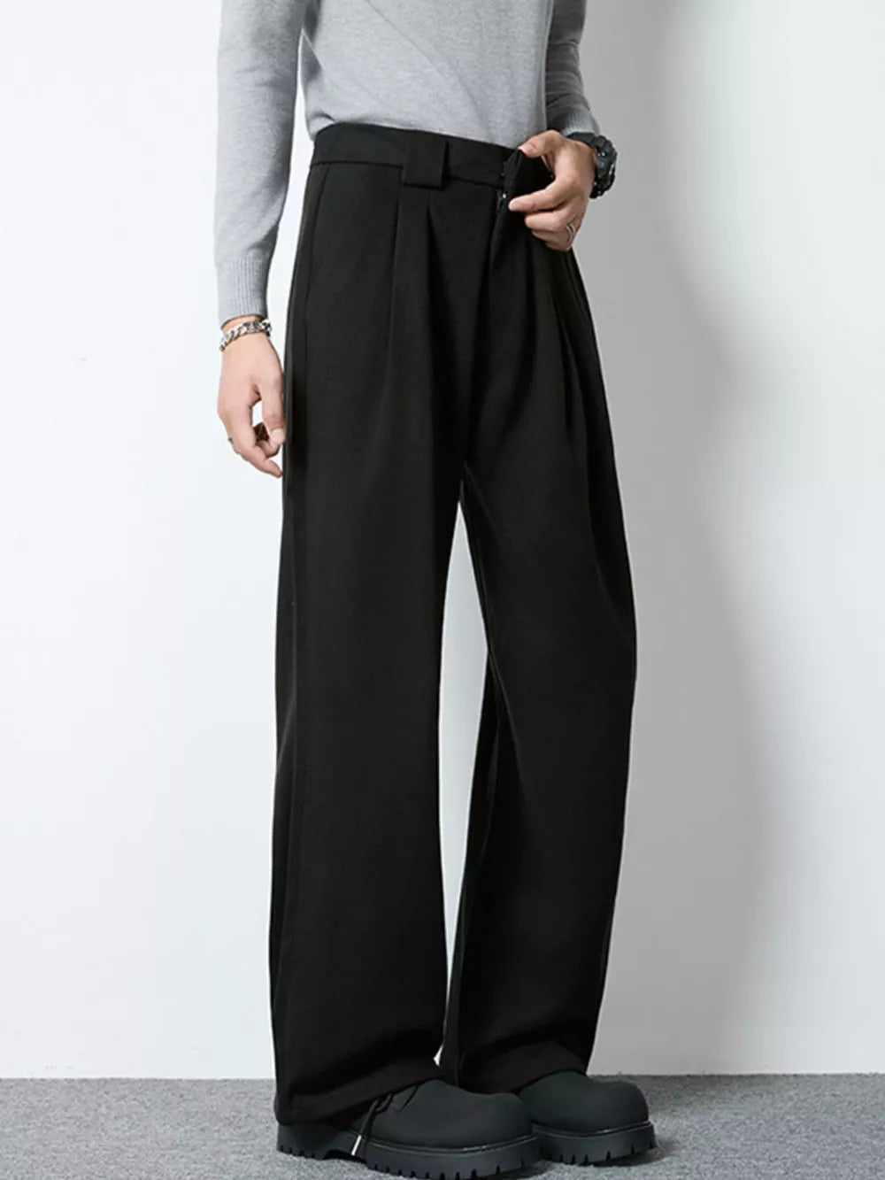 Men's black wide-leg pleated dress pants with a relaxed fit.