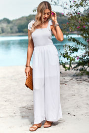 White smocked bodice tie-strap palazzo jumpsuit with wide legs and pockets.