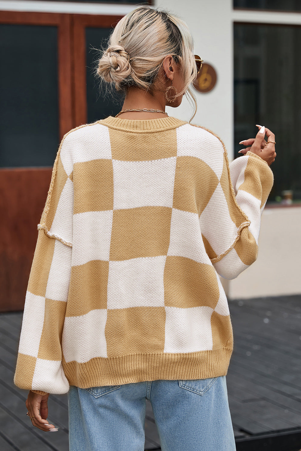 Checkerboard knit relaxed crewneck sweater in tan and white with balloon sleeves.