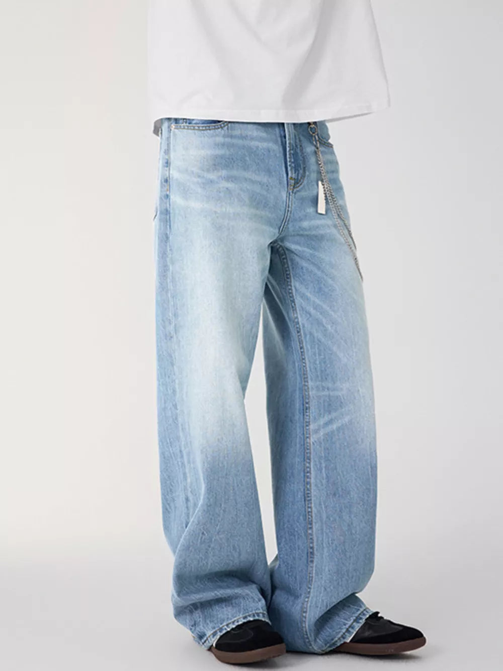Light wash denim wide-leg jeans with a chain detail and relaxed fit.