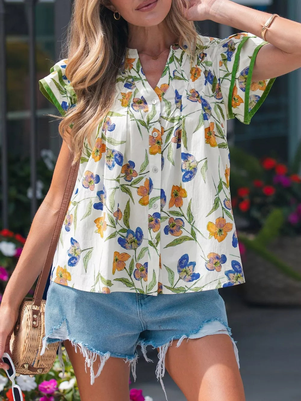 Vibrant floral cotton shirt with V-neck, button front, and ruffled green trim on sleeves.