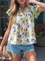 Vibrant floral cotton shirt with V-neck, button front, and ruffled green trim on sleeves.