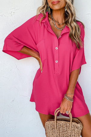Oversized hot pink shirt romper with buttons and pockets, short sleeves, collared neckline.