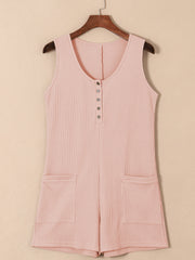 Blush pink waffle knit button-down romper with pockets and a scoop neckline.
