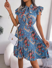 Turquoise floral mini dress with ruffle sleeves, pussy bow neckline, and pleated A-line skirt.