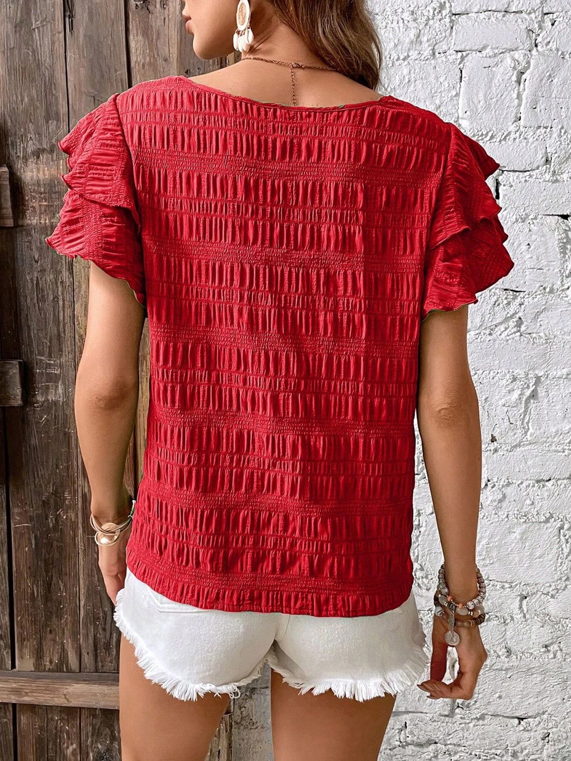Red textured smocked blouse with ruffle sleeves.