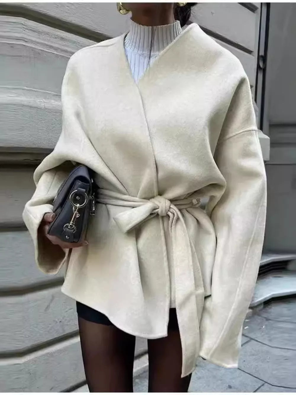 Beige belted trench coat with tie waist and dropped shoulders.