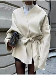 Beige belted trench coat with tie waist and dropped shoulders.
