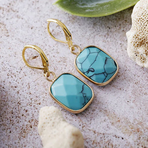 Turquoise stone and gold drop earrings with lever back closure.