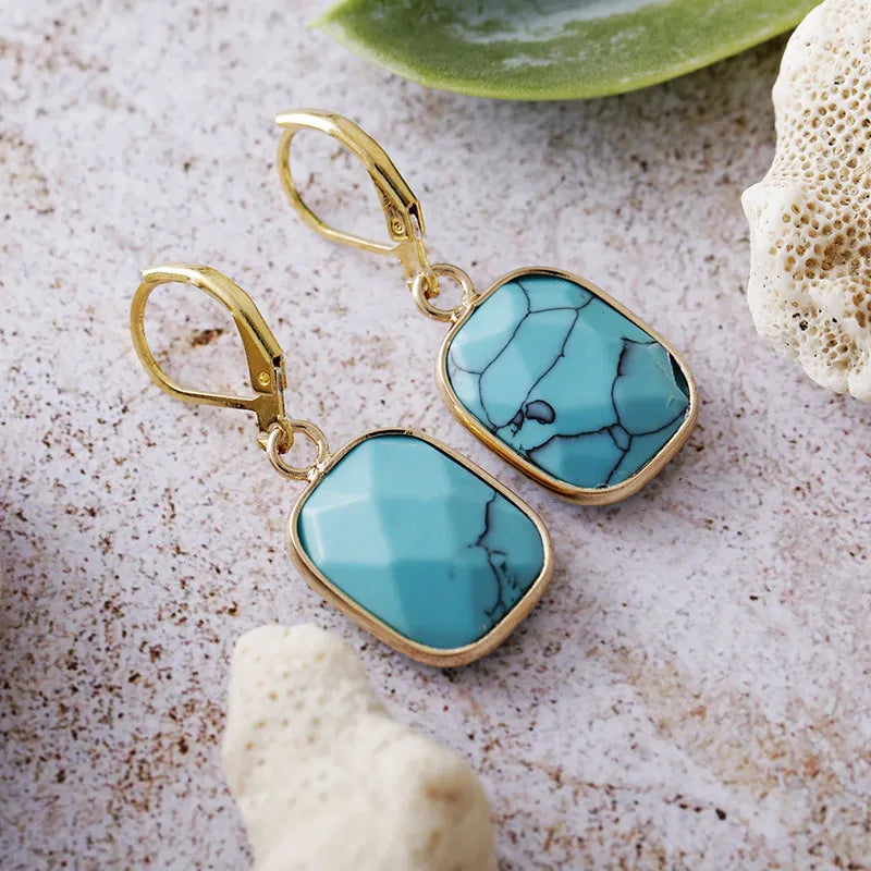 Turquoise stone and gold drop earrings with lever back closure.
