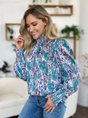 High neck abstract print blouse in sky blue and violet with smocked cuffs.