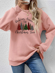 Blush pink crewneck sweatshirt with a graphic Christmas tree print and text that reads Rocking Around the Christmas Tree.