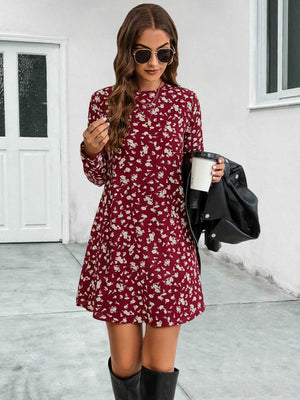 Deep red floral swing mini dress with long sleeves and round neckline.