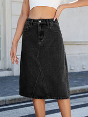 Black denim midi skirt with panel seams and a raw hem.