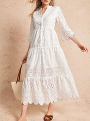 White eyelet tiered midi dress with button front and bell sleeves.