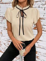 Apricot frilled tie-neck maternity blouse with black trim and short sleeves.