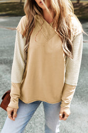 Colorblock hoodie with textured sleeves and V-neck detail in tan and cream.