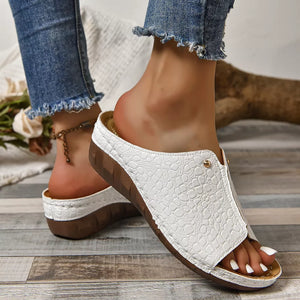White glossy crocodile-embossed wedge sandals with a slip-on design.