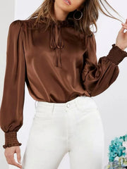 Brown satin tie-neck blouse with shirred cuffs and puff sleeves