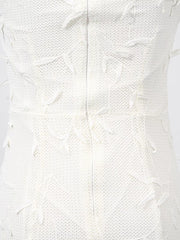 White midi dress with textured fabric and floral applique details.