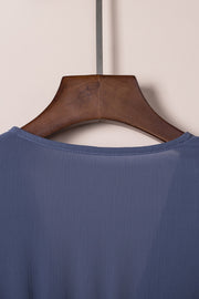 Dusty blue V-neck mini dress with subtle vertical texture and ruffled bow detail.