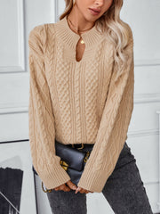 Camel cable knit sweater with keyhole neck and ribbed cuffs.